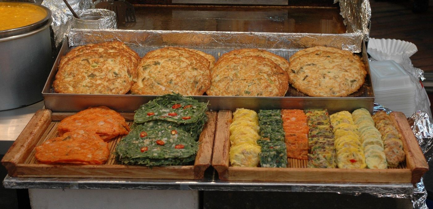 Griddles of Korean pancakes and fried snacks at Gwangjang Market, Seoul